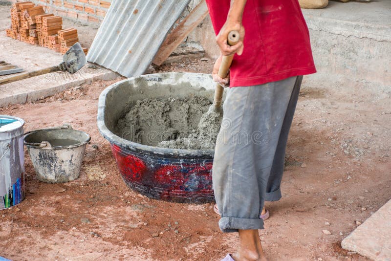 Construction Worker Manually Mixing Concrete in Mixer Tray Stock Photo