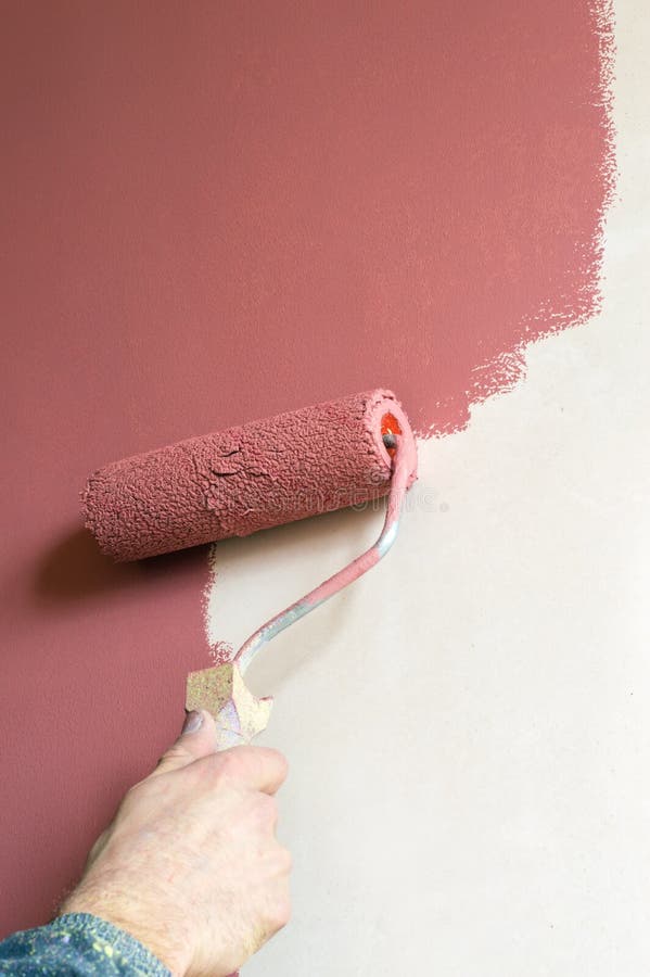 Construction Worker Paints the Wall Paint with a Roller Stock Image
