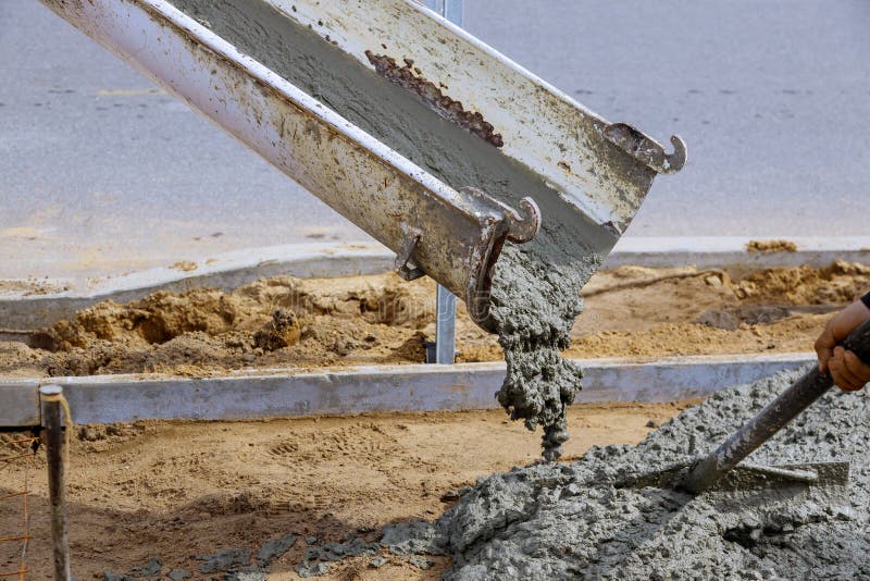 Worker pouring cement mix concrete in bucket Stock Photo