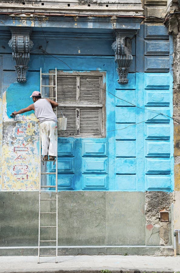 Construction worker renovates facade of old colonial building in Havana Vieja, Cuba