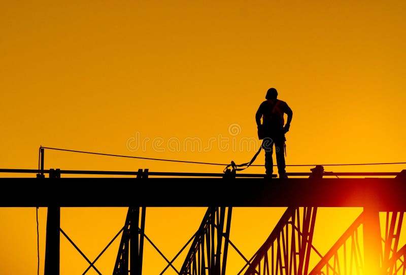 Bauarbeiter steht auf Stahlträger der Gebäude bei Sonnenaufgang.