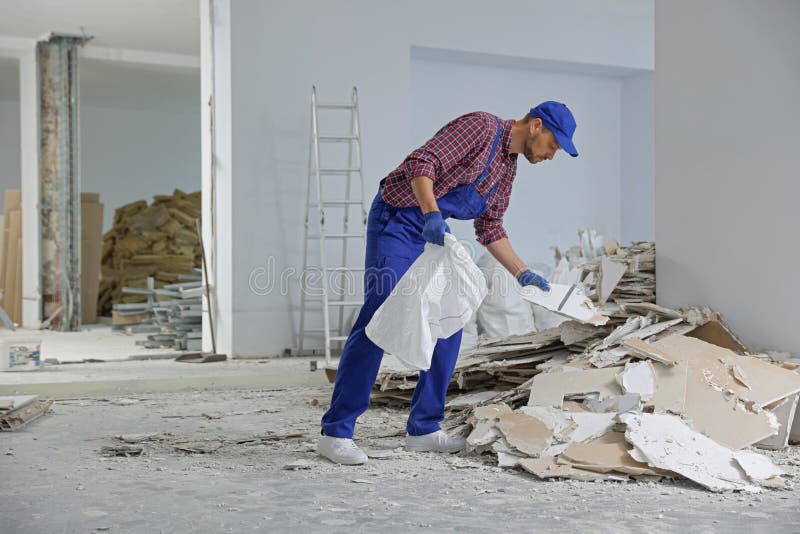 Construction Worker with Used Building Materials in Room Prepared for Renovation Stock Photo