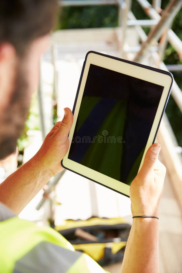 Construction Worker Using Digital Tablet On Building Site. Application, close.