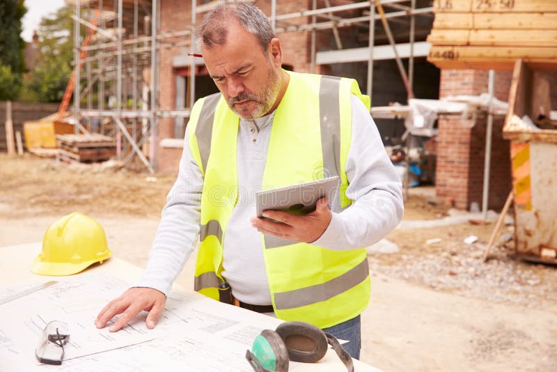 Construction Worker Using Digital Tablet On Building Site stock image