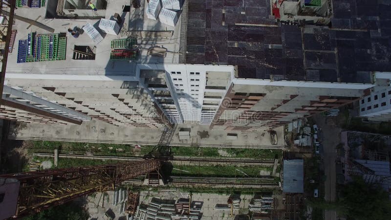 Construction workers building an apartment building in a field, aerial view