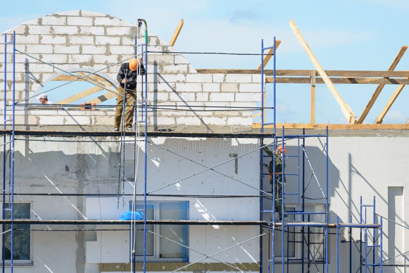 Construction Workers Carry Out Work on Plastering and Insulation