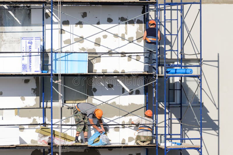 Construction Workers Carry Out Work on Plastering and Insulation