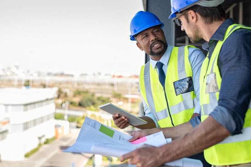 Construction workers talking about new construction site with copy space. Engineers in mechanical factory reading instructions. Architect in construction uniform holding blueprint and discussing. Architect uniform stock images, royalty-free photos and pictures