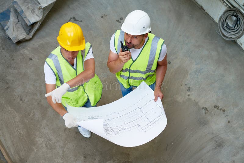 Construction Workers Wrapped up in Discussion royalty free stock photo