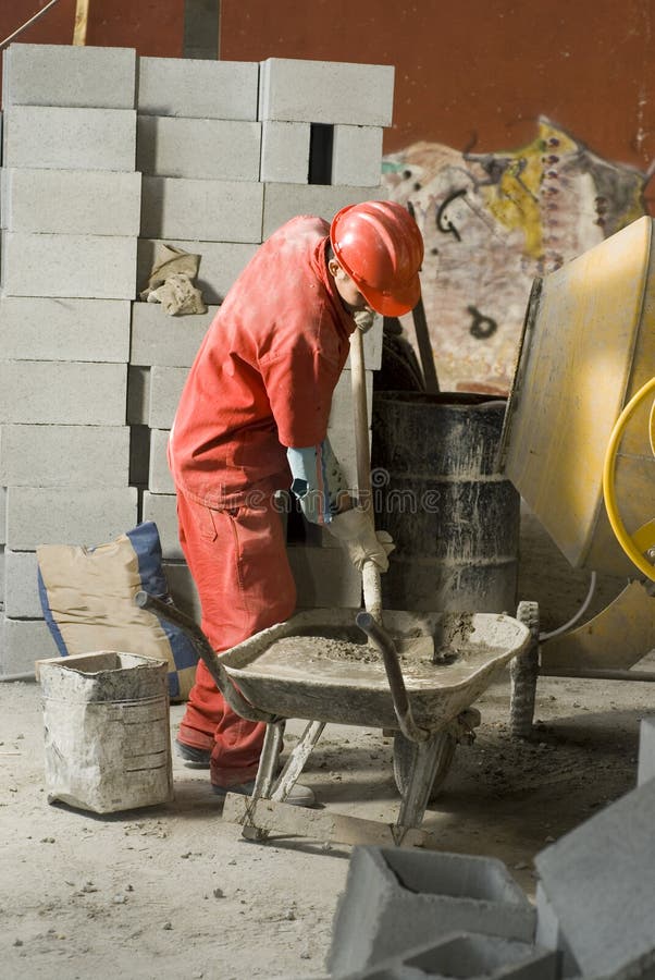 Il lavoratore è in piedi davanti a una pila di blocchi di cenere.