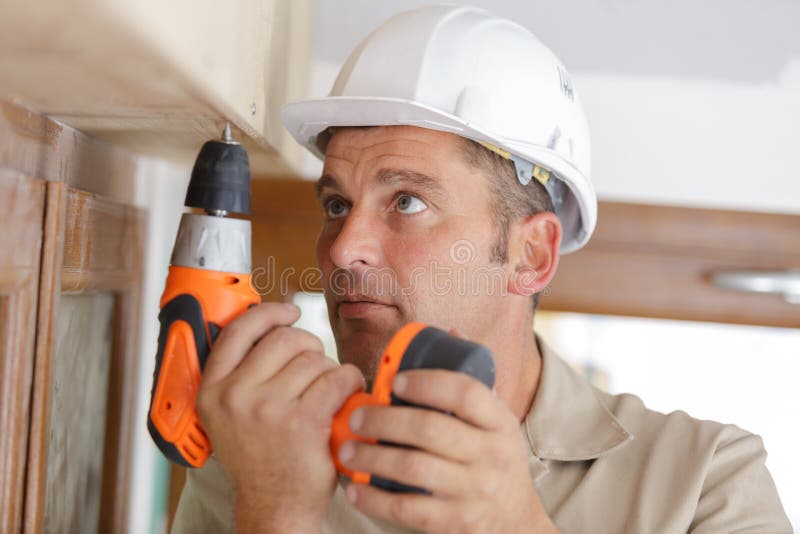 Constructor de hombres usando taladro imagen de archivo