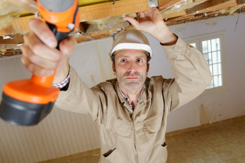 Constructor masculino con sobrecarga de taladro inalámbrico fotos de archivo libres de regalías