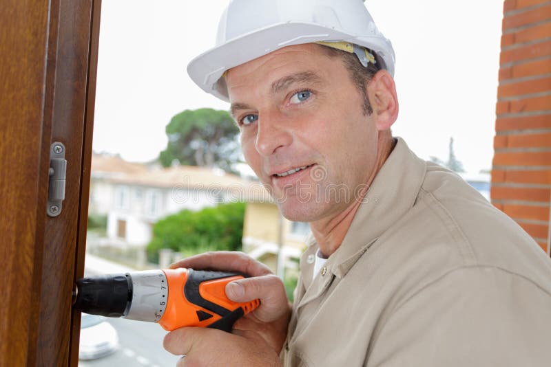 Constructor masculino maduro usando taladro inalámbrico fotografía de archivo libre de regalías