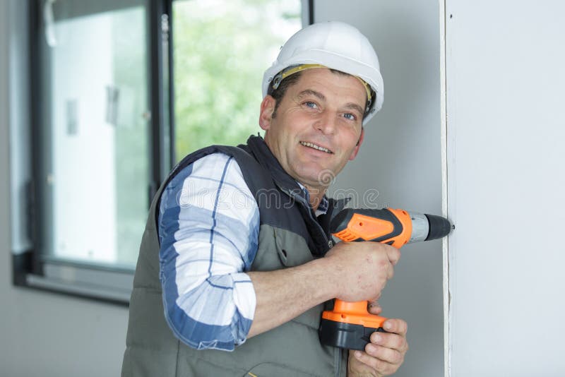 Constructor o propietario de la casa mediante perforación eléctrica imágenes de archivo libres de regalías