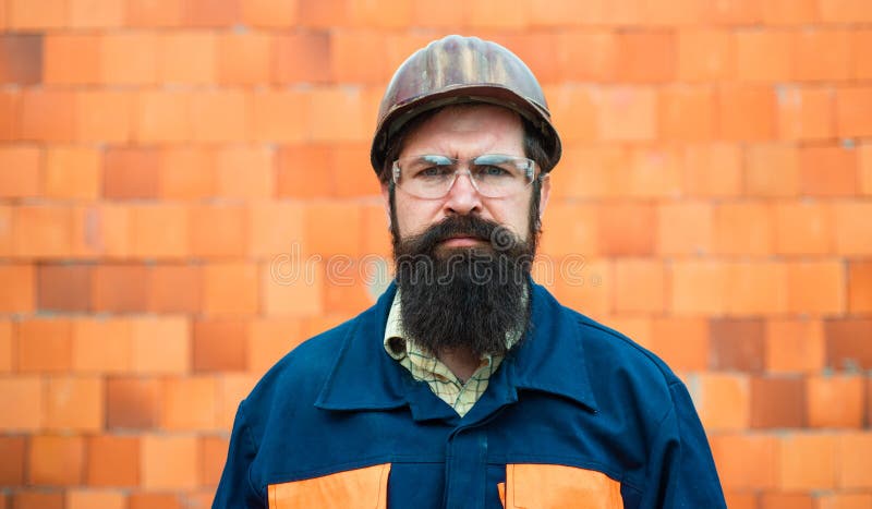 Constructor Trabajador mecánico del retrato Hombre barbudo en traje con el casco de la construcción Retrato del ingeniero hermoso imagenes de archivo Constructor Trabajador mecánico del retrato Hombre barbudo en traje con el casco de la construcción Retrato del ingeniero hermoso imagenes de archivo
