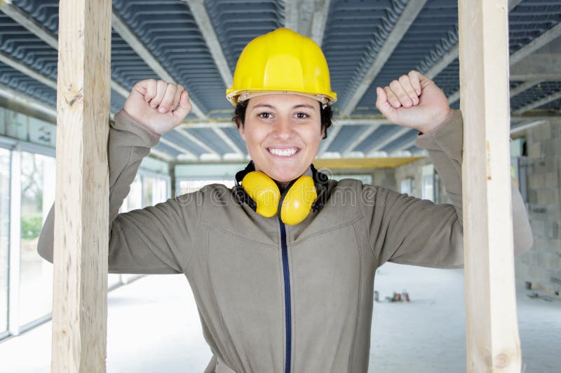 Constructora femenina mirando a través de la puerta de madera en el lugar de construcción imágenes de archivo libres de regalías