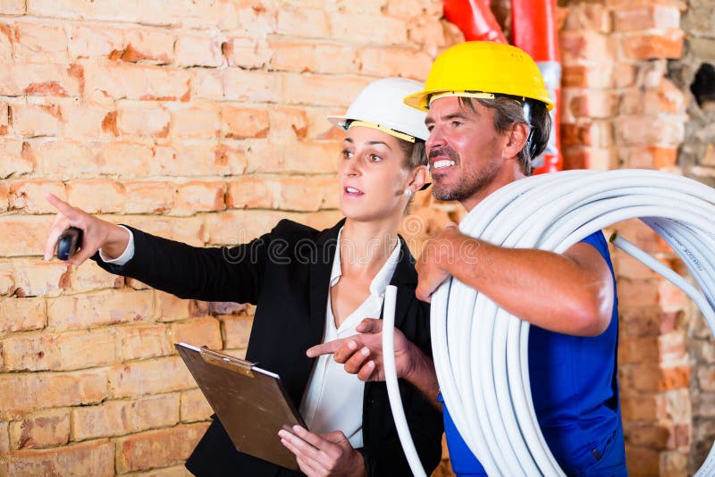 Pedreiro e arquiteto a trabalhar num estaleiro fotografia de stock