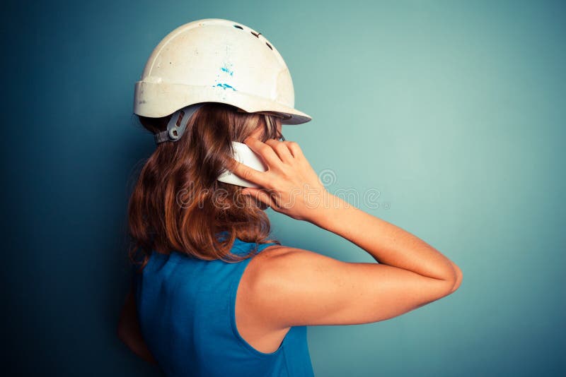 Construtor fêmea novo no telefone fotos de stock Construtor fêmea novo no telefone fotos de stock
