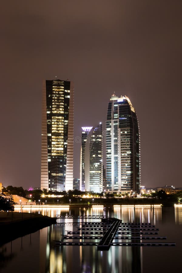 Construção alta com reflexão no lago na noite fotografia de stock Construção alta com reflexão no lago na noite fotografia de stock