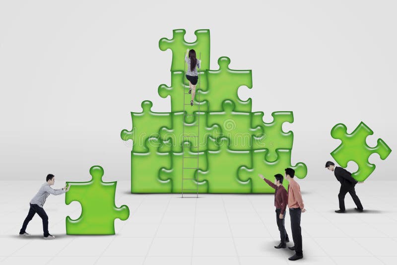 Equipa de negócios a trabalhar em conjunto para montar um puzzle imagens de stock royalty free