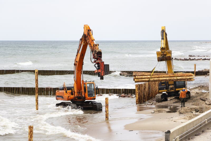Construção e reforço da costa, equipamento de construção na costa de mar fotos de stock Construção e reforço da costa, equipamento de construção na costa de mar fotos de stock