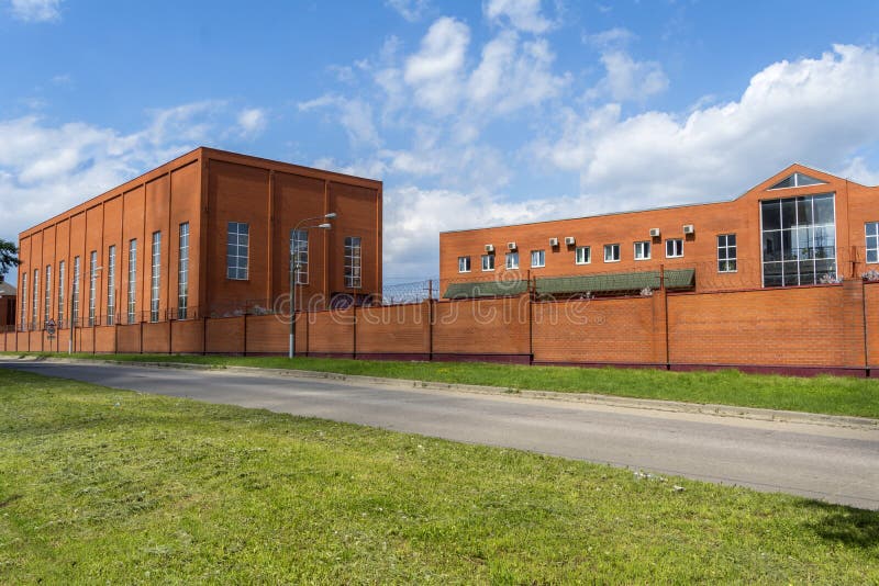 Construção industrial com prédio de escritórios Sala da produção feita do tijolo Cerca do tijolo vermelho Fábrica pequena imagens de stock royalty free Construção industrial com prédio de escritórios Sala da produção feita do tijolo Cerca do tijolo vermelho Fábrica pequena imagens de stock royalty free