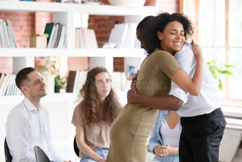 Consulente di dipendenza dello psicologo della donna che abbraccia tipo sostenente alla sessione del gruppo