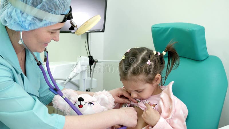 A consulta do doutor OTORRINOLARINGOLÓGICO, frio, procedimento médico, otolaryngologist trata o infante, criança do exame médico