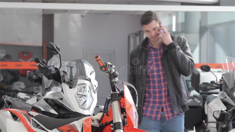 Consultant praat over de telefoon op motorfiets salon