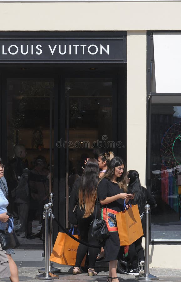 CONSUMERS with LOUIS VUITTON SHOPPING BAG Editorial Stock Image