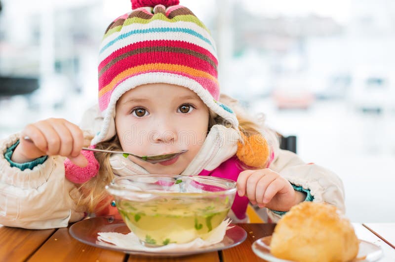 Toddler girl eating in outdoor cafe. Toddler girl eating in outdoor cafe