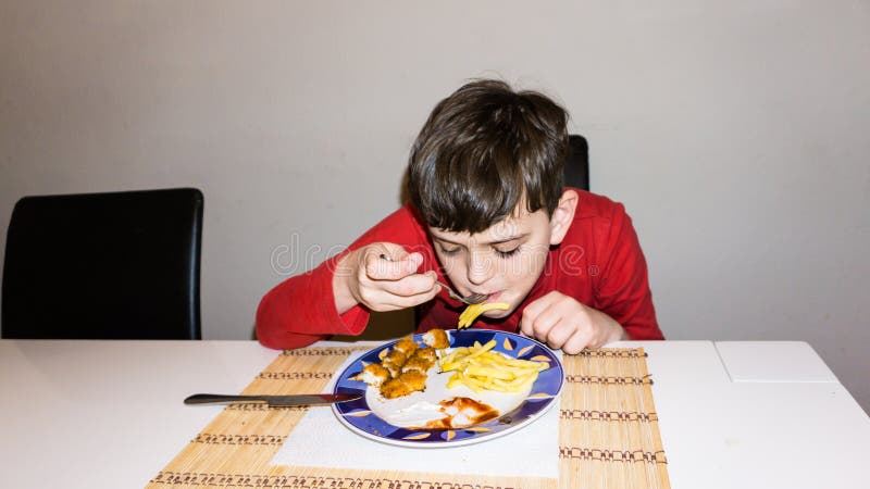 Consumición del hijo autístico de la comida del niño de la nutrición de la salud del muchacho foto de archivo Consumición del hijo autístico de la comida del niño de la nutrición de la salud del muchacho foto de archivo