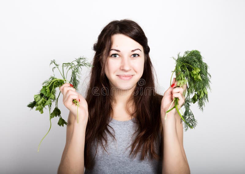 Consumición hermosa de la mujer joven verduras opción, perejil o eneldo comida sana - concepto fuerte de los dientes imagen de archivo Consumición hermosa de la mujer joven verduras opción, perejil o eneldo comida sana - concepto fuerte de los dientes imagen de archivo