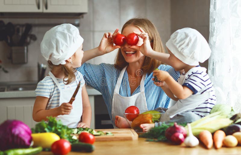 Consumición sana La madre y los niños felices de la familia prepara el veget fotografía de archivo libre de regalías Consumición sana La madre y los niños felices de la familia prepara el veget fotografía de archivo libre de regalías