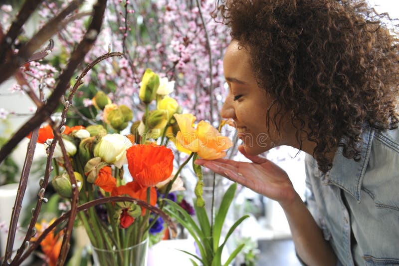 Consumismo: Donna che odora i fiori freschi.