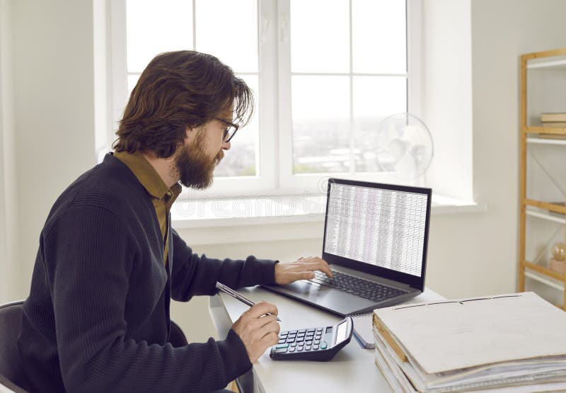 Contabilul masculin calculează performanța financiară a companiei utilizând calculatorul și software-ul pentru laptop. royalty free stock photo