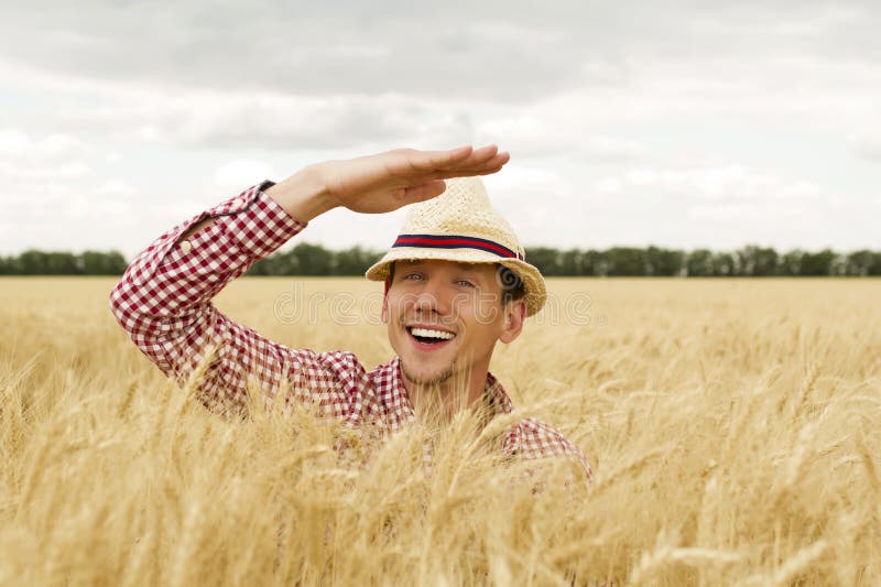 Contadino caucasico felice e sorridente, orgoglioso di fronte ai campi di grano che guarda al suo futuro fotografia stock