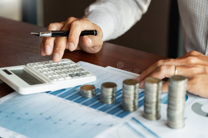Contador Calculating do homem de neg? cios em documentos dos dados e em pilha de moedas, o investimento da pilha do dinheiro das e imagem de stock royalty free
