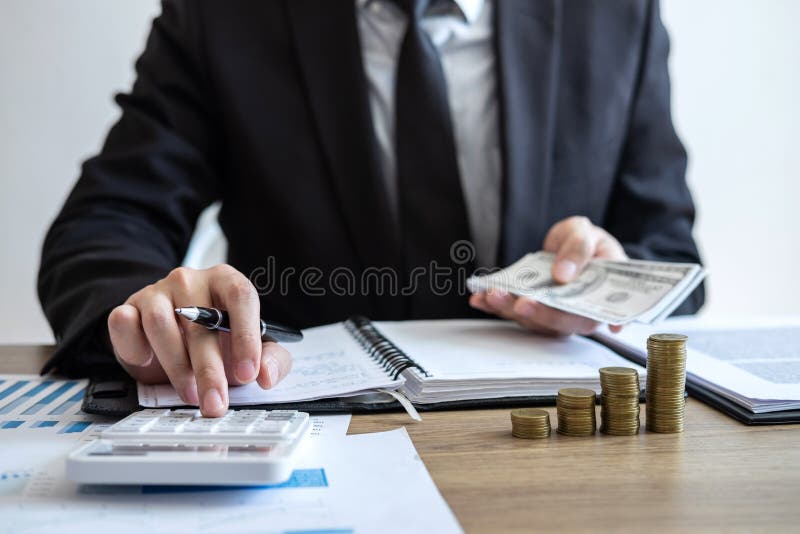 Contador do homem de negócios que conta o dinheiro e que faz anotações no relatório que faz finanças e para calcular sobre o cust imagens de stock