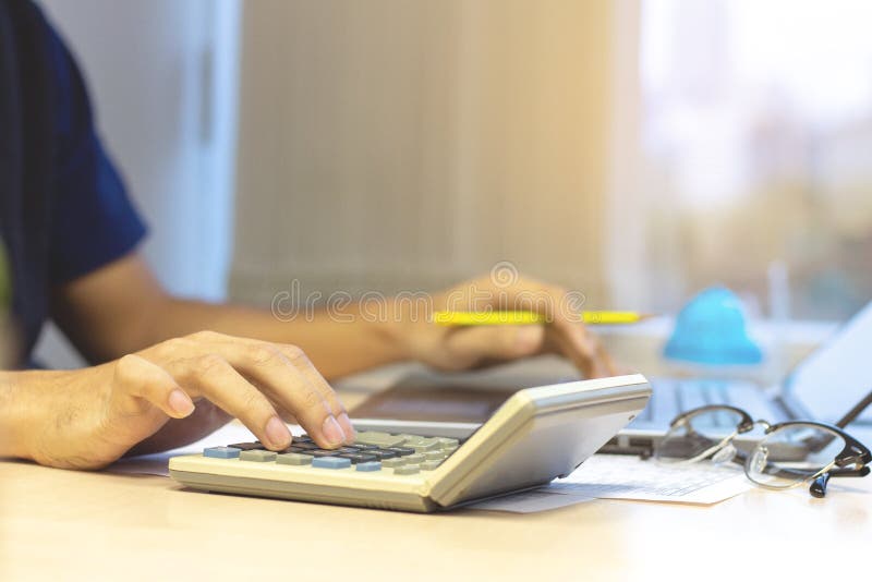 Contador do homem de negócios que usa a calculadora e o portátil para o calculati fotos de stock