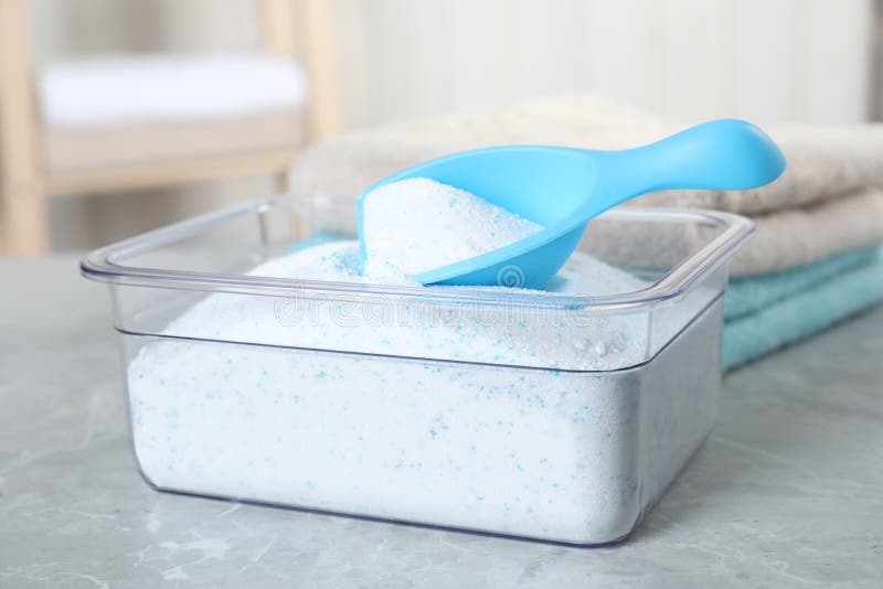 Container and Measuring Scoop with Laundry Detergent on White Stock