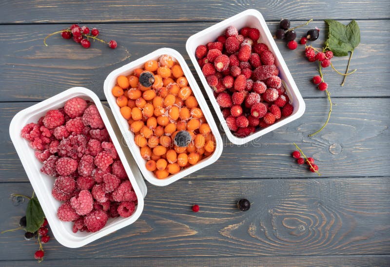 Containers with frozen berries from the refrigerator. The concept of frozen food, long-term storage products.