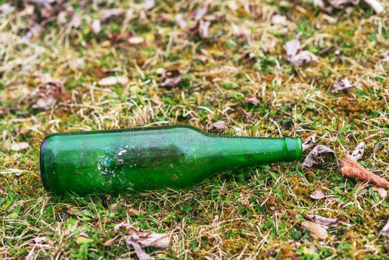 Contamination of the Environment by Humans. Glass Bottle Thrown on the Garbage on the Meadow