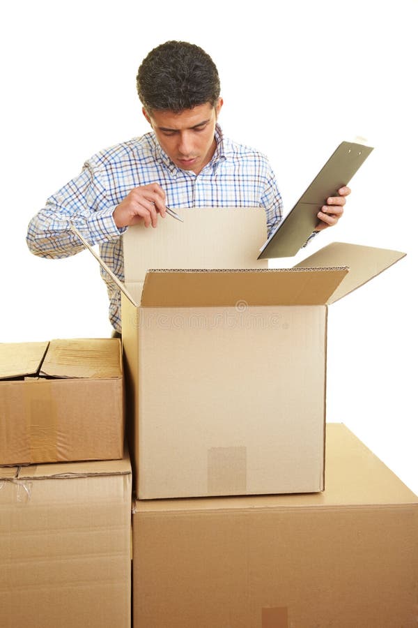 Man with clipboard counting the content of cardboard boxes. Man with clipboard counting the content of cardboard boxes