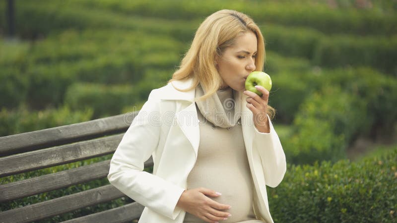 Contar con náusea de la sensación de la mujer mientras que come la manzana, náuseas matinales, toxemia almacen de metraje de vídeo