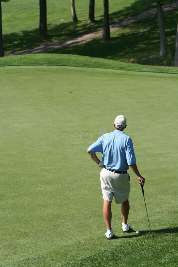 Jugador de golf lectura colocar de verde, él piensa próximo.