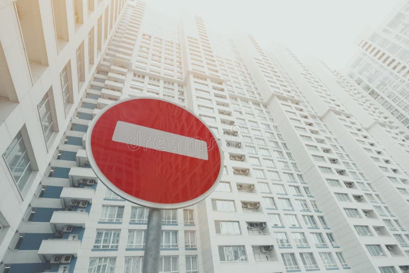 Contemporary white and grey skyscraper, red stop road sign below. Contemporary white and grey skyscraper apartment building with a lot of regular balconies and stock images Contemporary white and grey skyscraper, red stop road sign below. Contemporary white and grey skyscraper apartment building with a lot of regular balconies and stock images