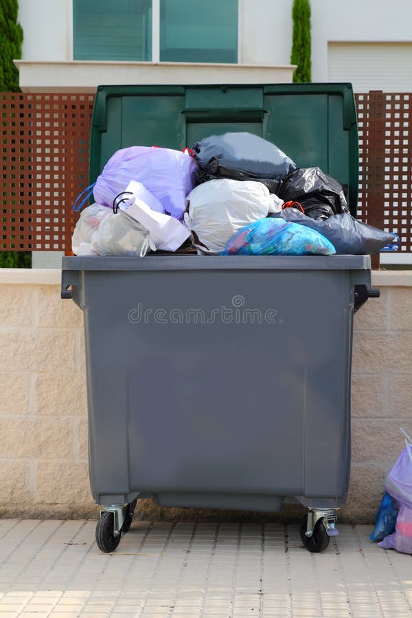 Trash garbage full of bags container in street. Trash garbage full of bags container in street