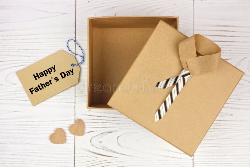 Happy Fathers Day card and opened shirt and tie gift box on a white wood background. Top view. Happy Fathers Day card and opened shirt and tie gift box on a white wood background. Top view