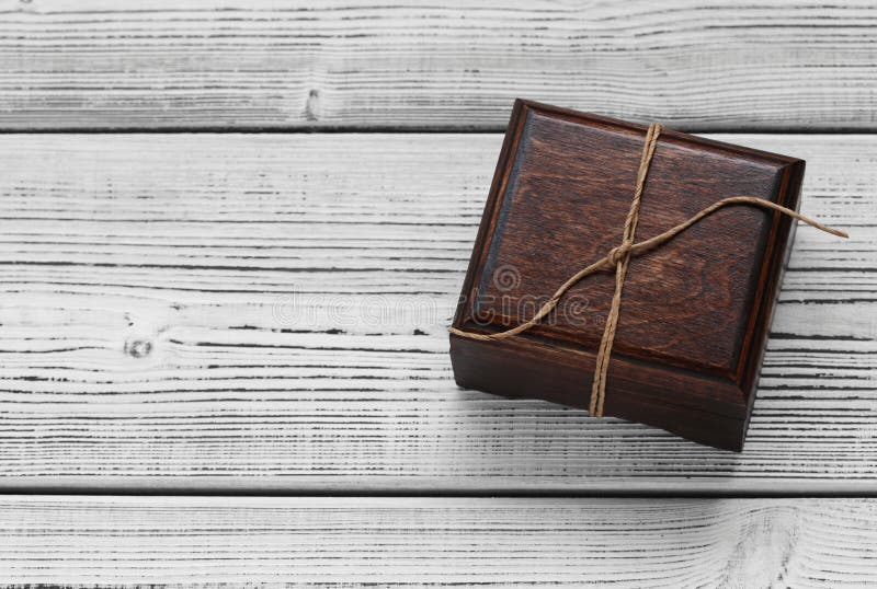 Contenitore di gioielli di legno su fondo bianco di legno Regalo legato con una corda immagine stock libera da diritti